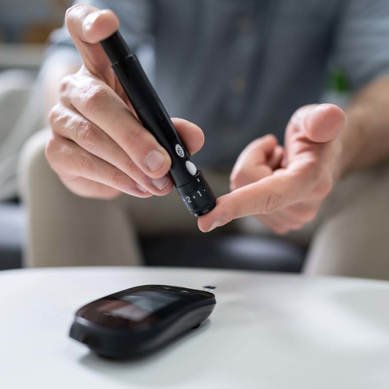Person benutzt Diabetes Messgerät