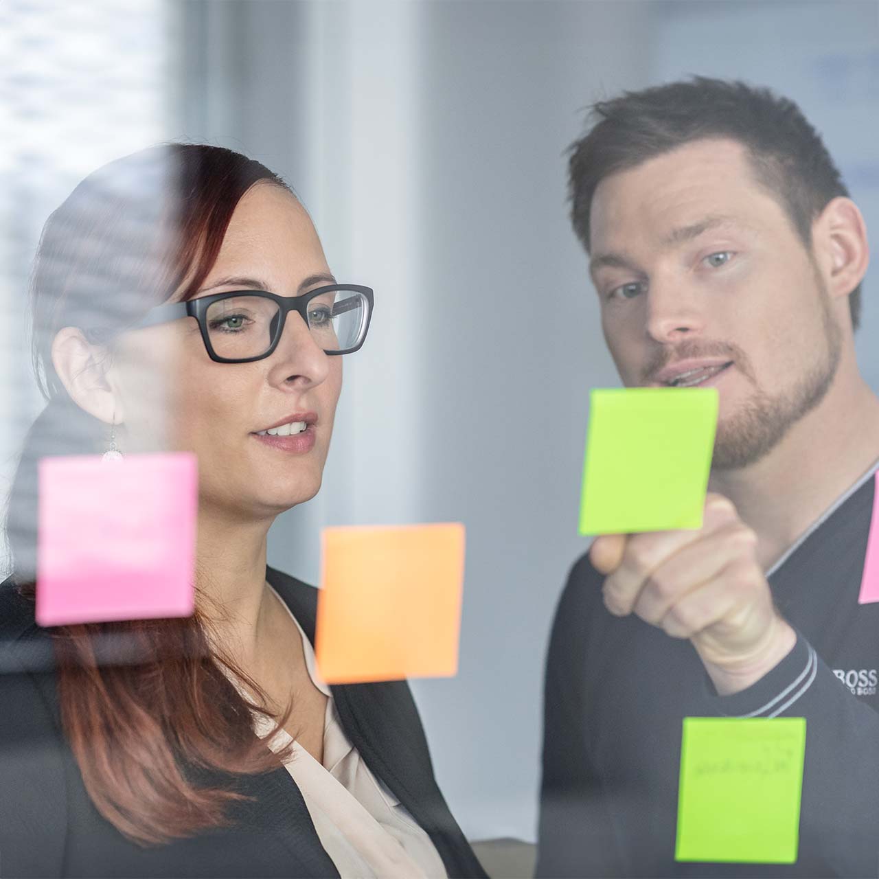 Zwei User-Research-Berater:innen an PostIt-Wand