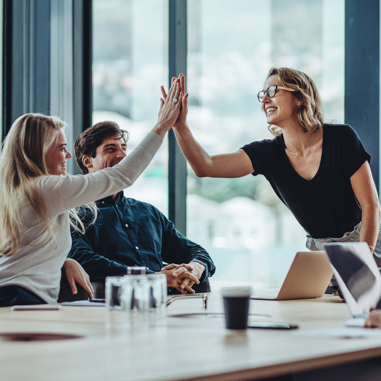 UX-Team gibt High-Five an Tisch