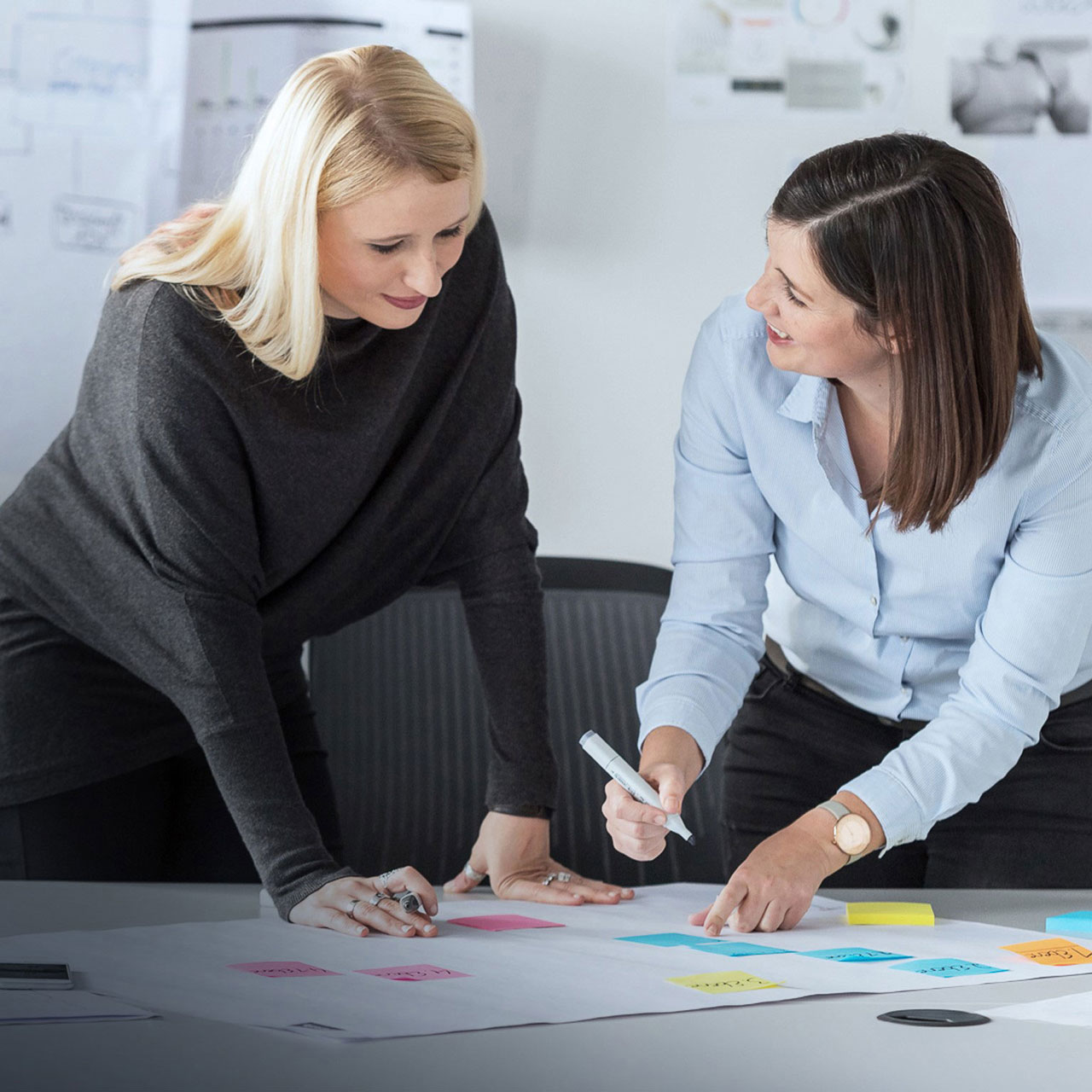 UX Coach und Coachee in Austauschsituation am Tisch