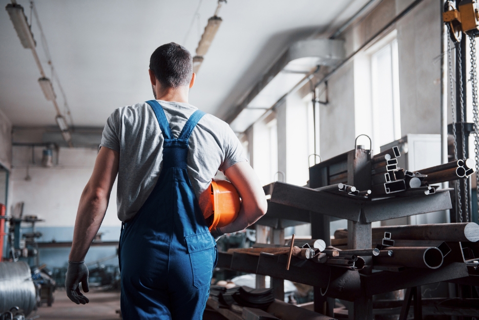Arbeiter läuft in einer Maschinenhalle.